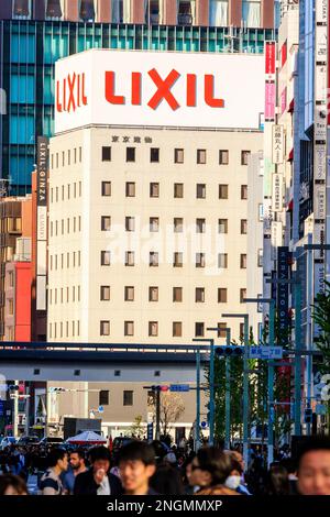 Tokyo, Ginza. La galleria Lixil Ginza edificio di mattoni bianchi catturati in condizioni di luce solare intensa. Compressi in prospettiva con il più alto edificio come sfondo. Foto Stock