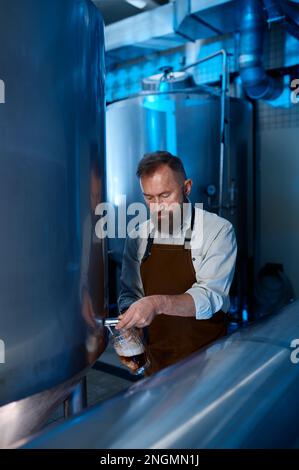 Birreria master degustazione di qualità di birra artigianale presso lo stabilimento di produzione Foto Stock