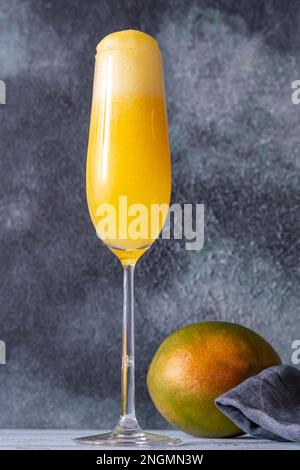 Flauto bicchiere di Mango Mimosa cocktail su sfondo grigio Foto Stock