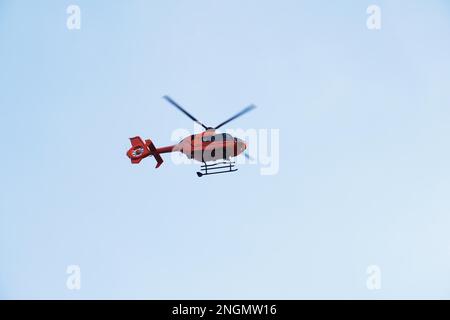 Soccorso elicottero o ambulanza aerea - Red Air Medical Services heli copter midair contro il cielo blu Foto Stock