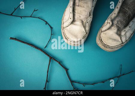 sneaker da donna vecchie senza lacci su sfondo blu. Foto Stock