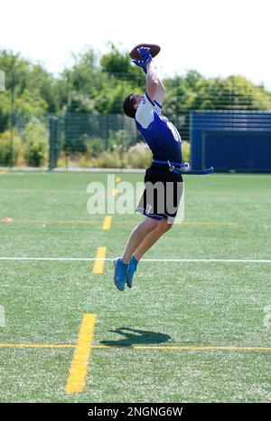 Duelli aerei tra i giocatori di opposizione durante una partita di Flag Football in Galles. Foto Stock