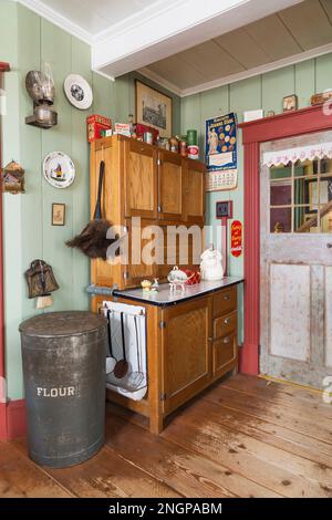 Antico buffet in legno con prodotti da cucina vintage e decorazioni in cucina con tavole di legno di pino usate all'interno della vecchia casa del 1835. Foto Stock