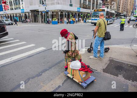 Vista ravvicinata della donna senza casa con effetti personali sulla strada che attraversa il cart al crosswalk di Manhattan, New York. STATI UNITI. Foto Stock