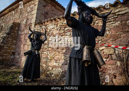 Luzon, Spagna. 18th Feb, 2023. Due uomini vestiti come 'diavolo di Luzon' attendono la partenza della parata durante la celebrazione del carnevale che corre per le strade della città di Luzon. La festa dei 'Diavoli di Luzon' è una celebrazione ancestrale. I diavoli sono coperti di olio e fuliggine, sulle loro teste indossano corna di toro, i loro denti sono fatti di patate, indossano un campanello attaccato alla loro cintura e spaventare gli abitanti. Credit: SOPA Images Limited/Alamy Live News Foto Stock