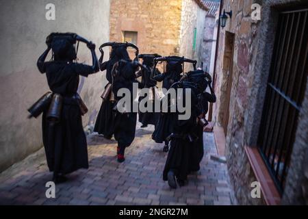 Luzon, Spagna. 18th Feb, 2023. Le persone vestite come 'Diavoli di Luzon' durante la celebrazione carnevale che corre per le strade della città di Luzon. La festa dei 'Diavoli di Luzon' è una celebrazione ancestrale. I diavoli sono coperti di olio e fuliggine, sulle loro teste indossano corna di toro, i loro denti sono fatti di patate, indossano un campanello attaccato alla loro cintura e spaventare gli abitanti. Credit: SOPA Images Limited/Alamy Live News Foto Stock