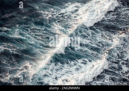 Onde oceaniche potenti che si affrettano a incontrare la costa Foto Stock