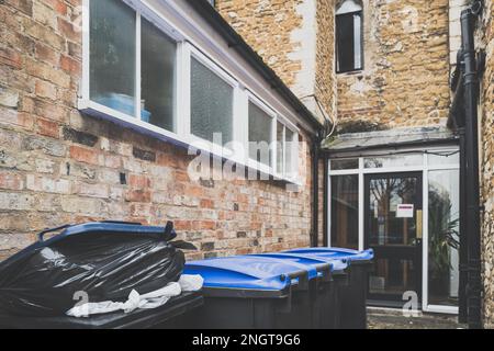 Rifiuti pieni e bidoni dei rifiuti visti sul retro di un ristorante, in attesa di essere raccolti. Foto Stock