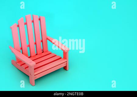 Contrasto di colore minimo con moderna sedia in legno rosa su sfondo blu pastello. Colori vivaci per essere diverso concetto solitario. Spazio di copia. Foto Stock