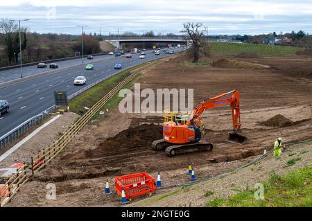 Datchet, Berkshire, Regno Unito. 17th febbraio, 2023. La mescola M4 di Datchet al confine con Slough, che è stata utilizzata per immagazzinare tutti i materiali delle opere di Smart Motorway, è attualmente in fase di smantellamento. Una trincea è stata scavata per seppellire il cablaggio. Enormi mucchi di terreno vengono rimossi e la recinzione protettiva intorno a due vecchi alberi di quercia è stata rimossa. La zona era precedentemente utilizzata come campi per il pascolo dei cavalli. Credito: Maureen McLean/Alamy Foto Stock