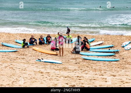 Gruppo di persone che hanno lezioni di surf a Manly Beach a Sydney Australia durante l'estate 2023 Foto Stock