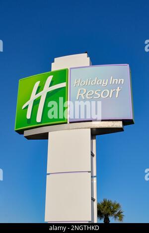 Galveston, Texas - 2023 febbraio: Cartello davanti all'hotel Holiday Inn Beach Resort con un cielo blu intenso Foto Stock