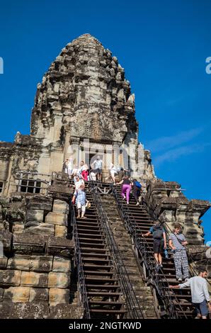 Turisti su una ripida scalinata che conduce ad una delle torri principali presso il famoso tempio antico di Angkor Wat in Cambogia. Foto Stock