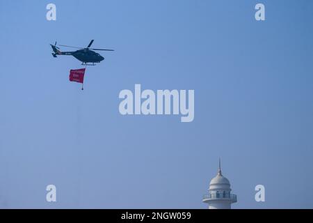 Kathmandu, Nepal. 19th Feb, 2023. Il 19 febbraio 2023 a Kathmandu, Nepal. Elicottero dell'esercito che sbatte la bandiera del "giorno nazionale della democrazia" vola sopra la cima di un'architettura di 72 metri 'Dharahara'. (Foto di Abhishek Maharjan/Sipa USA) Credit: Sipa USA/Alamy Live News Foto Stock