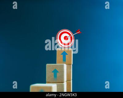 3d icona bersaglio sulla parte superiore dei blocchi di cubo di legno, grafico a barre con le frecce su sfondo blu. Processo di crescita aziendale, investimenti, reddito, Foto Stock