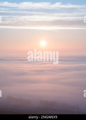 Il sole sorge sopra un'incredibile inversione invernale vista da Almscliffe Crag a Lower Wharfedale in una gelida mattinata di metà inverno. Foto Stock