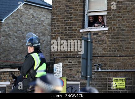 Londra, Regno Unito. 19th Feb, 2023. I residenti locali guardano attraverso la loro finestra mentre i tifosi del West Ham camminano verso lo stadio guidato dagli ufficiali di polizia durante la partita della Premier League al Tottenham Hotspur Stadium, Londra. Il credito dell'immagine dovrebbe essere: Paul Terry/Sportimage Credit: Sportimage/Alamy Live News Foto Stock