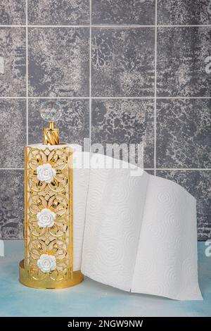 Asciugamani di carta da cucina e bagno su holder.Rolling carta asciugamani in piedi su sfondo di legno blu. Foto Stock