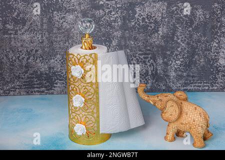 Asciugamani di carta da cucina e bagno su holder.Rolling carta asciugamani in piedi su sfondo di legno blu. Foto Stock