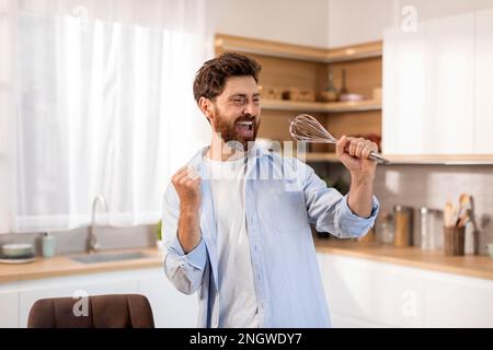 Felice adulto caucasico maschio superstar in t-shirt bianca canta la canzone al microfono immaginario frusta Foto Stock