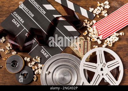 negativi strisce con film clapperboard bobine biglietti popcorn scrivania in legno. Bella foto Foto Stock