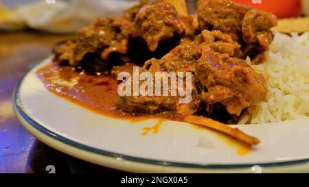 Primo piano di piccante montone di Rogan josh o curry di capra con riso aromatico Basmati o Chawal Foto Stock
