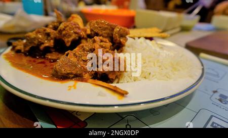 Primo piano di piccante montone di Rogan josh o curry di capra con riso aromatico Basmati o Chawal Foto Stock