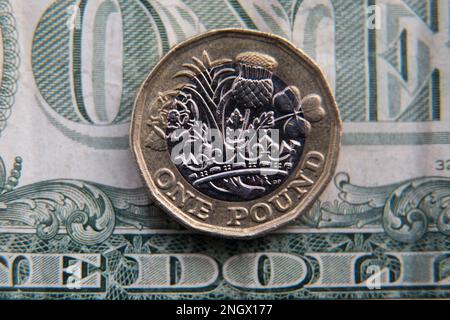 British Pound Coin seduta su un conto in dollari Foto Stock