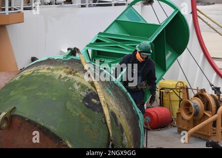 Petty Officer 3rd Class Austin Cass, un Boatswain’s Mate a bordo della USCGC Mackinaw (WLBB 30), lavora boe mentre la fresa è ormeggiata a Milwaukee, 30 novembre 2022. Come parte del dettaglio Aids to Navigation, BM3 Cass lavora con altri membri dell'equipaggio per ispezionare e fornire assistenza alle boe nell'area di responsabilità del CGC Mackinaw. Foto Stock