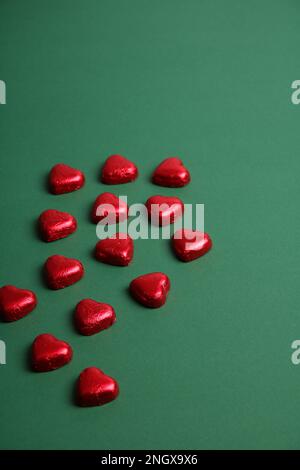 foto molti cuori rossi giacenti su uno sfondo verde primo piano Foto Stock