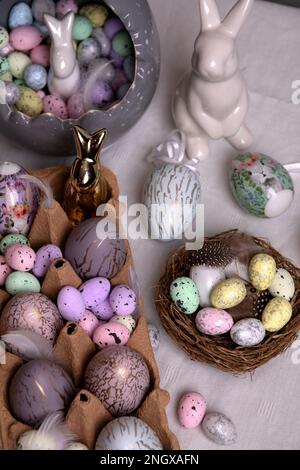 foto molte uova decorative colorate di pollo e quaglia e un coniglio bianco in ceramica Foto Stock