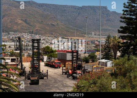 Città del Capo Sud Africa. 2023. Veicoli a carrello elevatore utilizzati nel terminale per container. Lo sfondo è Table Mountain. Foto Stock