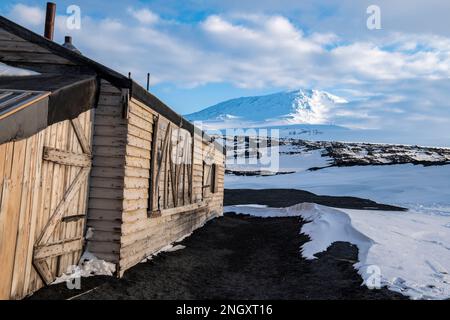 Antartide, Mare di Ross, Isola di Ross, Capo Evans. Vista esterna dello storico rifugio Scott's Hut con il Monte Erebus in lontananza. Foto Stock