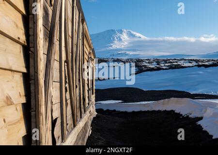 Antartide, Mare di Ross, Isola di Ross, Capo Evans. Vista esterna dello storico rifugio Scott's Hut con il Monte Erebus in lontananza. Foto Stock