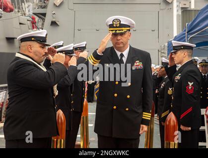 YOKOSUKA, Giappone (1 dicembre 2022) CMdR. Travis Montplaisir, comandante uscente del cacciatorpediniere missilistico guidato della classe Burke di Arleigh USS Howard (DDG 83), saluta mentre cammina attraverso i marciapiedi durante una cerimonia di cambio di comando a bordo della nave, schierato in avanti al comandante, Fleet Activities Yokosuka, dicembre 1. Howard viene assegnato al comandante, Task Force 71/ Destroyer Squadron (DESRON) 15, il più grande DESRON della Marina e la principale forza di superficie della flotta statunitense 7th. Foto Stock