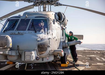 MAR MEDITERRANEO (1 dicembre 2022) Aviation Machinist’s Mate Airman Majorie Rogero, a destra, assegnato all’Helicopter Maritime Strike Squadron (HSM) 79, assiste nella chiusura di un elicottero MH-60R Seahawk sul ponte di volo del cacciatorpediniere missilistico guidato di classe Arleigh Burke USS Roosevelt (DDG 80) dopo il completamento dei trimestri di volo, 1 dicembre 2022. Roosevelt, attualmente collegata al Charles de Gaulle Carrier Strike Group, è in programma di schieramento negli Stati Uniti Naval Forces Europe area of Operations, impiegato dagli Stati Uniti Sesta flotta per difendere gli interessi degli Stati Uniti, alleati e partner. Foto Stock