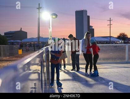 I membri del Desert Lighting Team e le loro famiglie pattinano su una pista di pattinaggio artificiale durante il Winterfest presso la base aeronautica Davis-Monthan, Ariz., 2 dicembre 2022. Winterfest è stato ospitato dal 355th Force Support Squadron e la 355th Wing Chapel per la comunità DM per celebrare le vacanze. Foto Stock