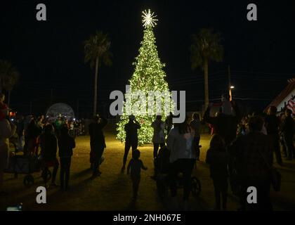 I membri del Desert Lighting Team e le loro famiglie osservano l'illuminazione di un albero durante il Winterfest alla base aeronautica Davis-Monthan, Ariz., 2 dicembre 2022. Il Winterfest, ospitato dallo Squadrone di supporto della forza del 355th e dalla Cappella dell'Ala del 355th, ha fornito una varietà di attività di vacanza tra cui arte e artigianato e gonfiabili a tema. Foto Stock