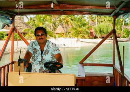 Isole Cook Aitutaki - 7 2010 Novembre; autista di una barca a laguna in una camicia tropicale che attraversa la laguna. Foto Stock