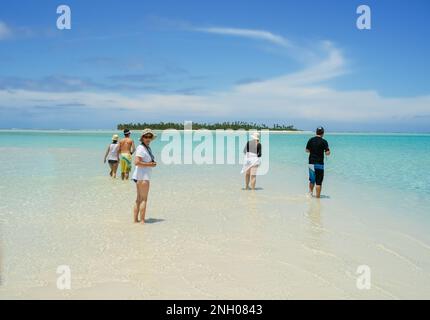 Aitutaki Cook Islands - 7 2010 novembre; i turisti di gruppo che guadono in un atollo poco profondo con orizzonte davanti e nuvole bianche e cielo blu sopra. Foto Stock