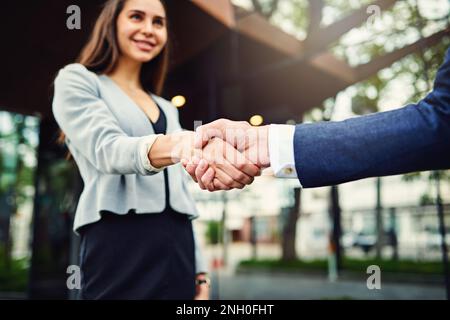 Espandi i tuoi contatti incontrando nuovi uomini d'affari. una bella giovane donna d'affari che scuote le mani con un uomo d'affari irriconoscibile fuori. Foto Stock