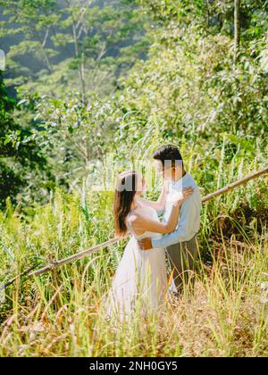 Giugno 01, 2022. Bali, Indonesia. Giorno di nozze con coppia elegante in foresta tropicale e sole. Foto Stock