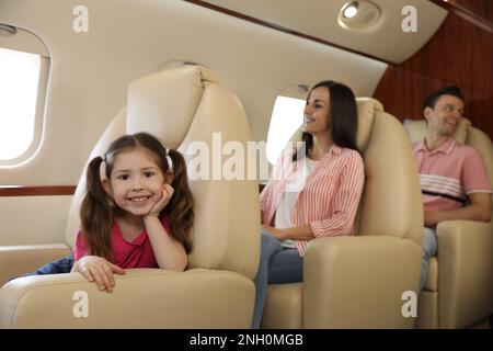 Famiglia felice insieme in aereo durante il volo Foto Stock