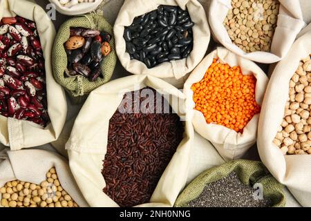 Grani e semi diversi come sfondo, vista dall'alto. Dieta vegetariana Foto Stock