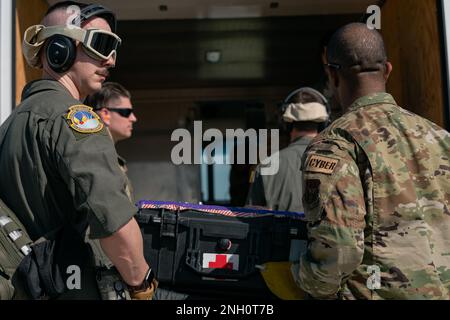 I militari assegnati allo Squadron di evacuazione Aeromedica 45th caricano l'apparecchiatura medica su un camion durante un'operazione di evacuazione simulata presso la base dell'aeronautica militare di MacDill, Florida, 5 dicembre 2022. Questo esercizio ha simulato un ambiente di spiegamento e migliorato le capacità degli Airmen di salvare i guerrieri feriti dal campo di battaglia con i motori di un aereo in funzione. Foto Stock