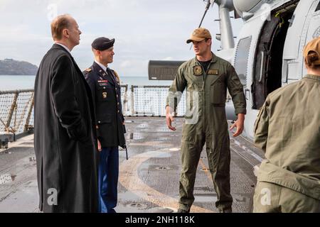 221205-N-TC847-1209 KOPER, Slovenia (5 dicembre 2022) Naval Air Crewman 2nd Classe Zachary Wilbanks, assegnato all'elicottero Maritime Strike Squadron (HSM) 46, mostra un elicottero MH-60R Sea Hawk in mostra al Segretario di Stato sloveno per la sicurezza internazionale Andrej Benedejcic e gli Stati Uniti Benjamin Shaha durante un tour dell'incrociatore missilistico guidato di classe Ticonderoga USS Leyte Gulf (CG 55), 5 dicembre 2022. Carrier Air Wing (CVW) 7 è la componente offensiva di Carrier Strike Group (CSG) 10, George H.W. Boccola CSG. Gli squadroni del CVW-7 sono lo Squadrone Strike Fighter (VFA) 86 Foto Stock