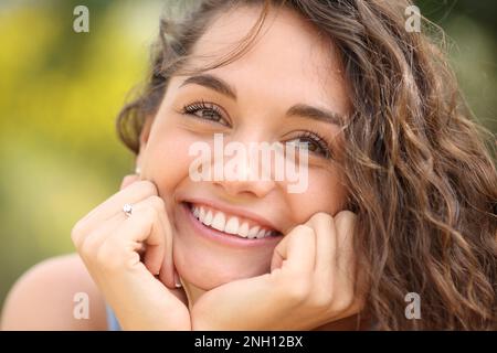 Vista frontale di una fidanzata felice che sorride guardando lontano Foto Stock