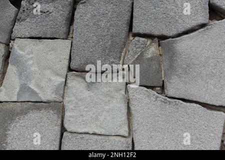 Struttura in muratura grigio pietra. Astratto sfondo neutro in grande pietra con tagli. Diseguali sentieri in muratura caotica, pareti, edifici. Un'architettura Foto Stock