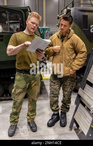 SPC Ole Kristian Sveen, un istruttore norvegese con Brigade North, fornisce istruzioni agli Stati Uniti Benjamin Roberson, un operatore di veicoli a motore con Battle Logistics Battaglione 8, 2D Combat Logistics Regiment, 2nd Marine Logistics Group, durante il corso Belted Vehicle a Setermoen, Norvegia, 6 dicembre 2022. Il corso Belted Vehicle è stato ideato per sviluppare Marines e altri membri dell'assistenza in modo da disporre di conoscenze tecniche e competenze sufficienti per il funzionamento di Bandvagn 206. Foto Stock