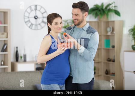 coppia incinta con tomatos freschi Foto Stock